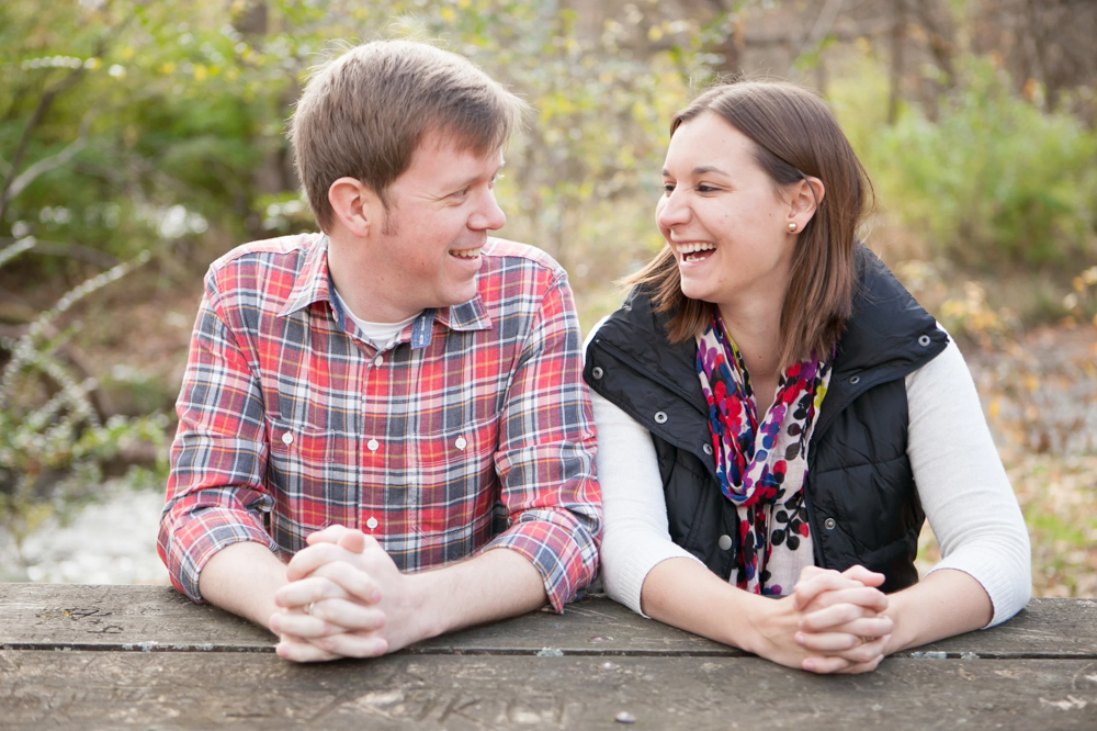 man and woman engagement picture at picnic table