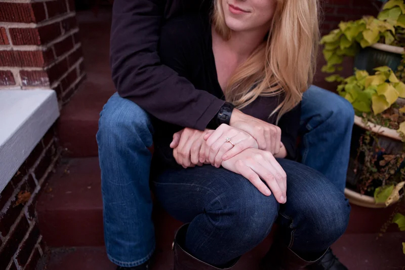 man and woman engagement image holding hands with ring