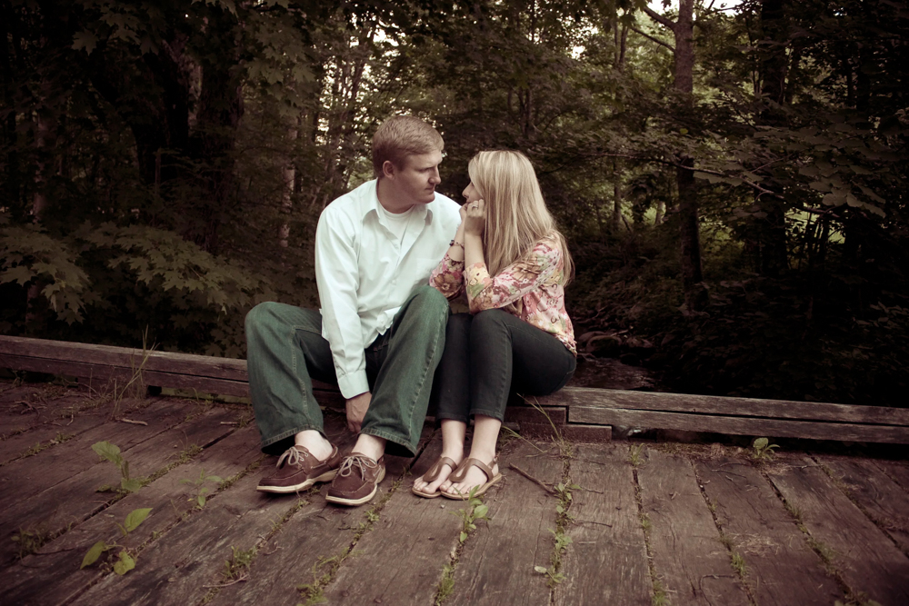 man and woman engagement image on wooden bridge