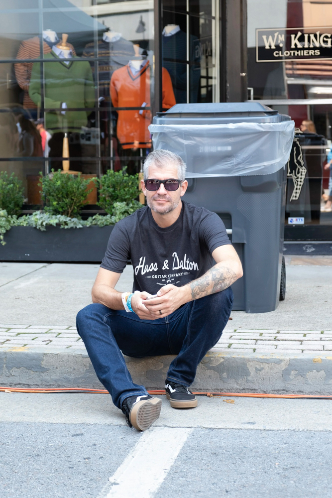 man sitting on the side of the street