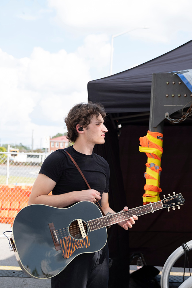 man holding guitar for music artist