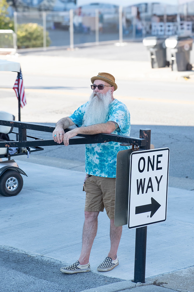 man standing next to one-way sign