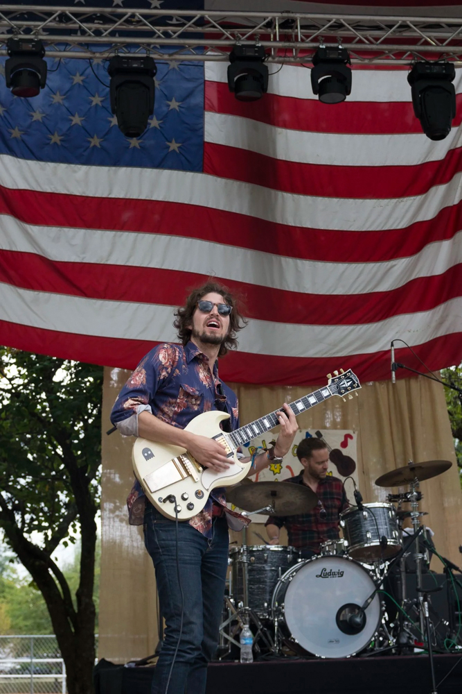 Man with Guitar in Front of American Flag